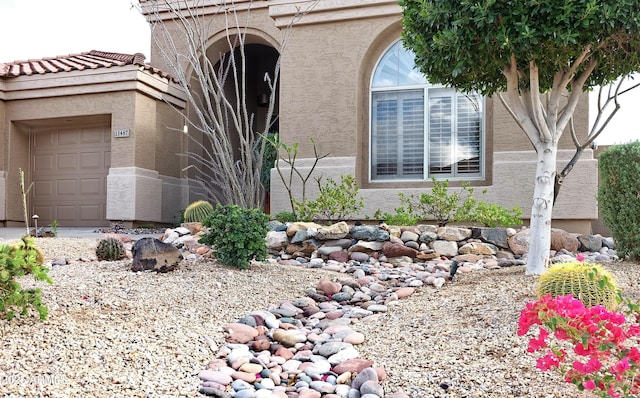 view of side of home with stucco siding and a garage