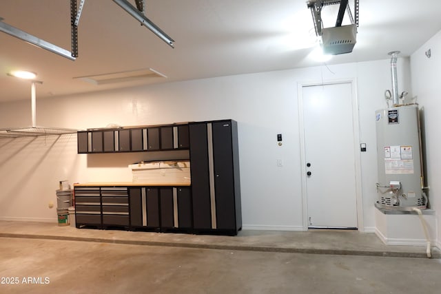 garage featuring gas water heater, baseboards, and a garage door opener