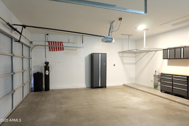 garage featuring a garage door opener and baseboards