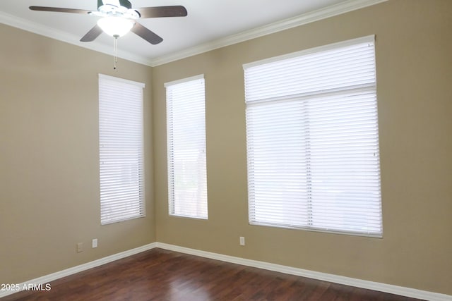 spare room featuring dark wood-type flooring, a ceiling fan, baseboards, and ornamental molding