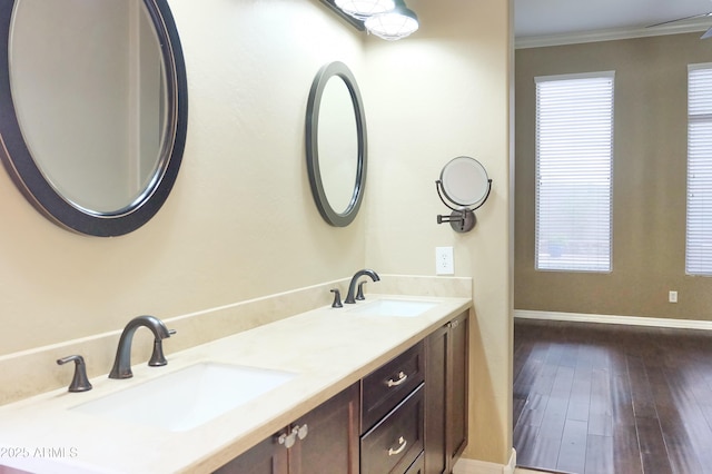 full bath featuring a sink, baseboards, wood finished floors, and crown molding