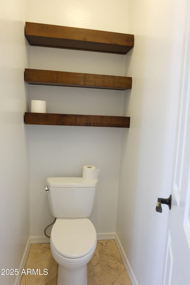 bathroom with tile patterned floors, baseboards, and toilet