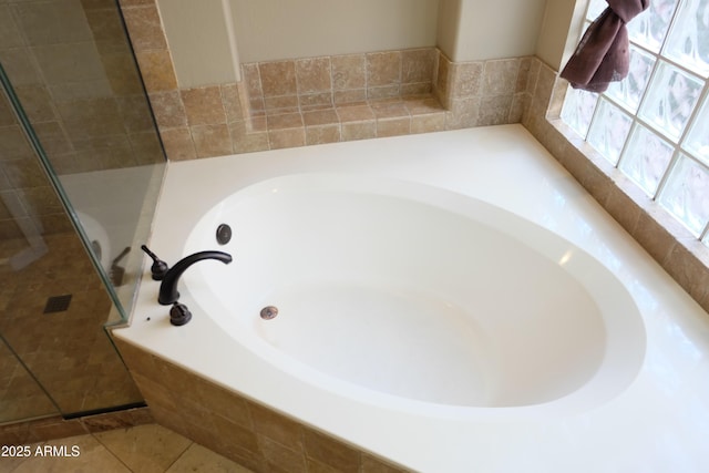 bathroom featuring tile patterned floors, a tile shower, and a bath