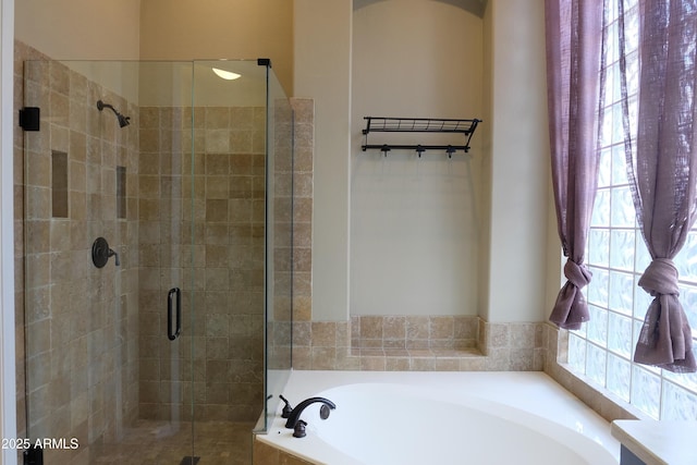 bathroom featuring a shower stall and a garden tub