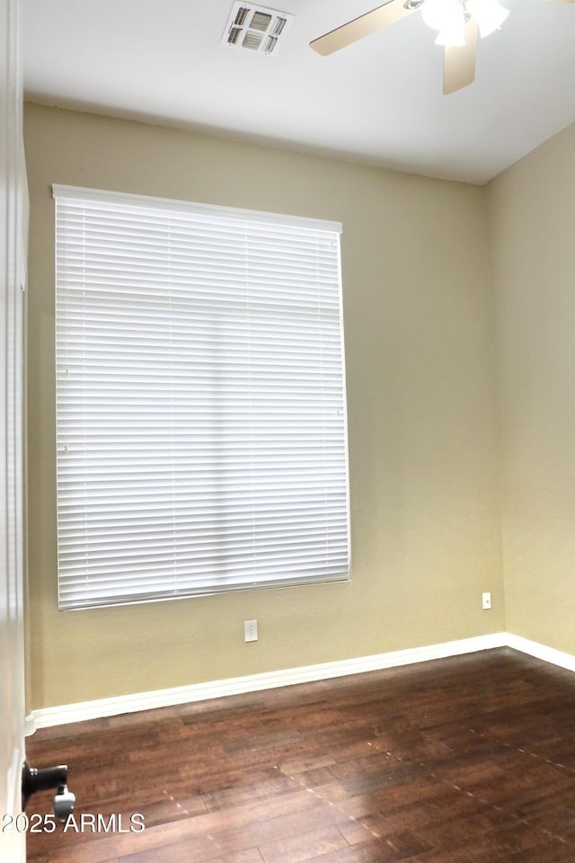 unfurnished room featuring hardwood / wood-style floors, visible vents, baseboards, and ceiling fan