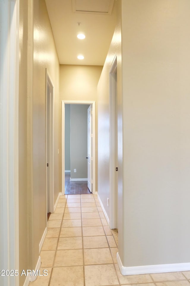 hallway with recessed lighting, baseboards, and light tile patterned flooring