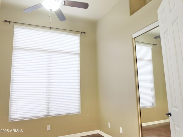 spare room featuring plenty of natural light, baseboards, and a ceiling fan