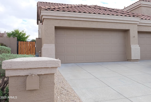 garage with fence and driveway