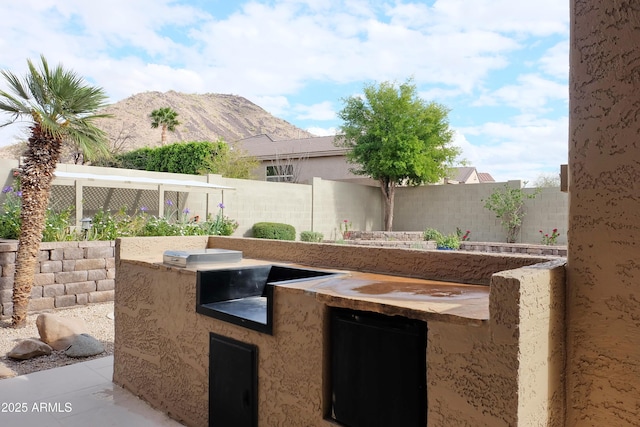 view of patio / terrace featuring a mountain view, area for grilling, and a fenced backyard