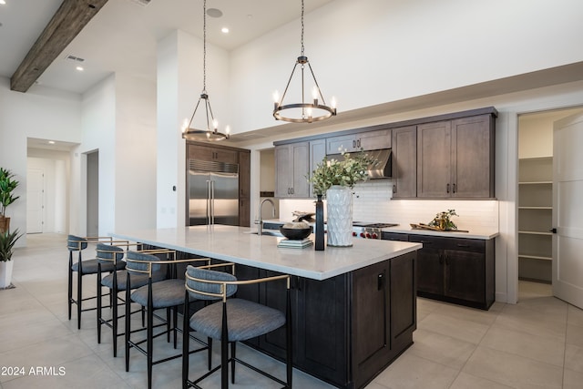 34749 N 83rd Way, Scottsdale, AZ 85266 - kitchen featuring a kitchen island with sink, pendant lighting, an inviting chandelier, tasteful backsplash, and stainless steel built in fridge