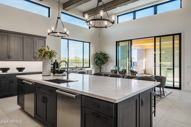 34749 N 83rd Way, Scottsdale, AZ 85266 - kitchen featuring beamed ceiling, backsplash, a center island with sink, a high ceiling, and decorative light fixtures
