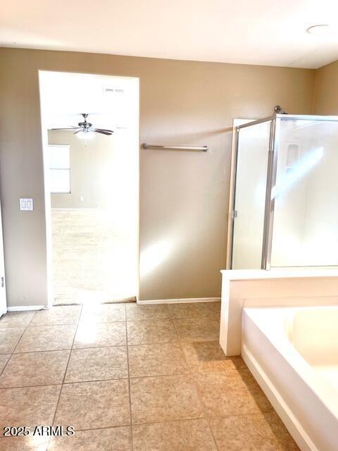 bathroom featuring a stall shower, baseboards, a ceiling fan, and a bath