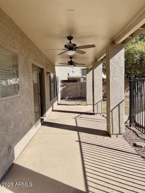 view of patio featuring ceiling fan and fence