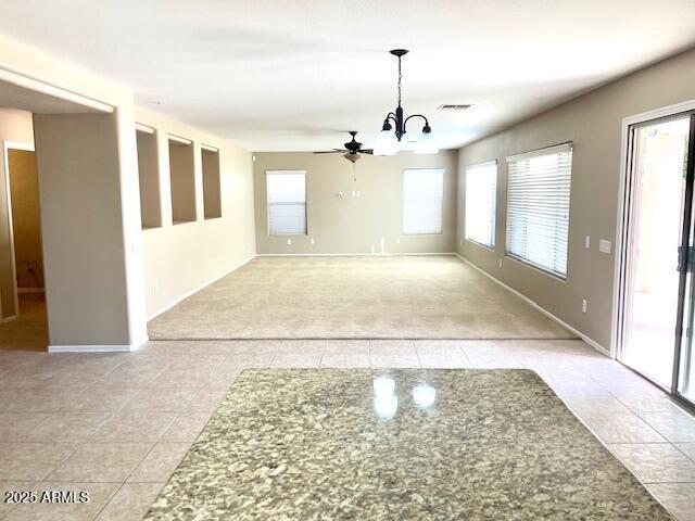 unfurnished dining area with light tile patterned flooring, a notable chandelier, visible vents, and baseboards