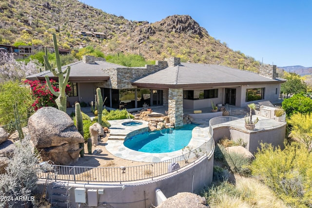 view of pool with an in ground hot tub, a mountain view, and a patio area