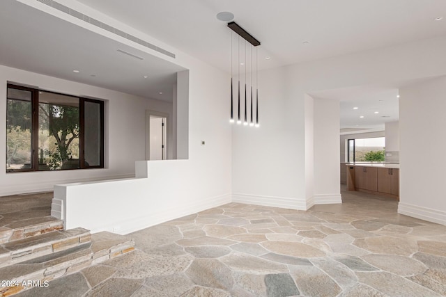 spare room featuring stone flooring, baseboards, and recessed lighting