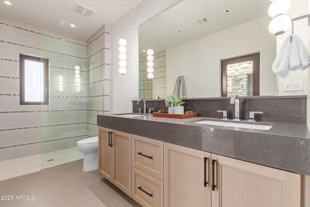 bathroom featuring a stall shower, visible vents, and a sink