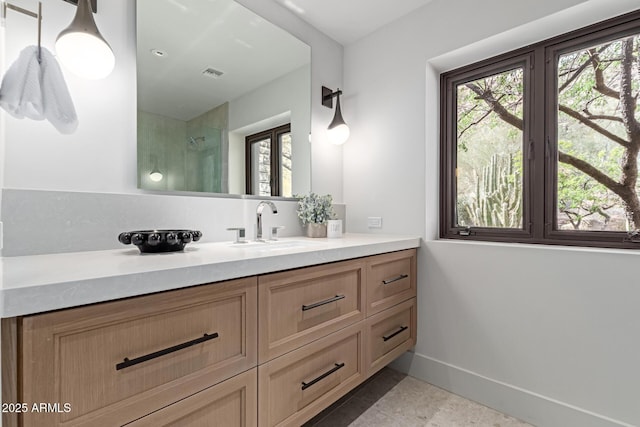 bathroom with baseboards, an enclosed shower, visible vents, and vanity