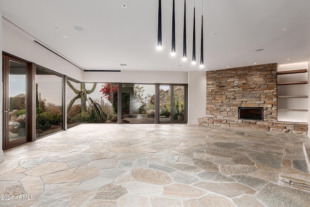 unfurnished living room featuring a stone fireplace