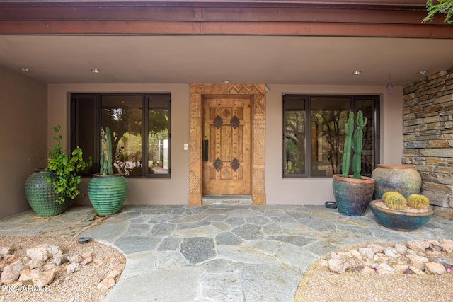 property entrance featuring stone siding and stucco siding