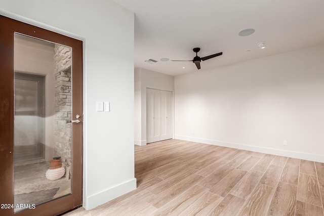 unfurnished room with light wood-style floors, visible vents, baseboards, and a ceiling fan