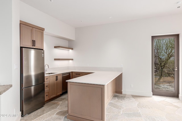 kitchen with a peninsula, stainless steel appliances, light countertops, open shelves, and a sink