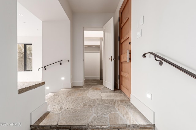 bathroom with stone finish flooring and a spacious closet