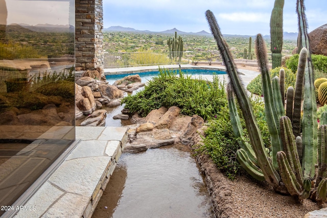 exterior space featuring fence, a mountain view, and a fenced in pool