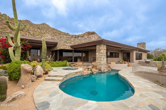 pool with a patio, a mountain view, and an in ground hot tub