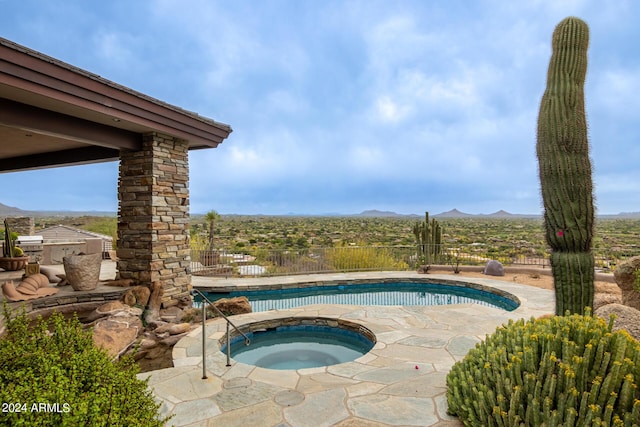 view of pool with fence, a mountain view, a fenced in pool, and an in ground hot tub