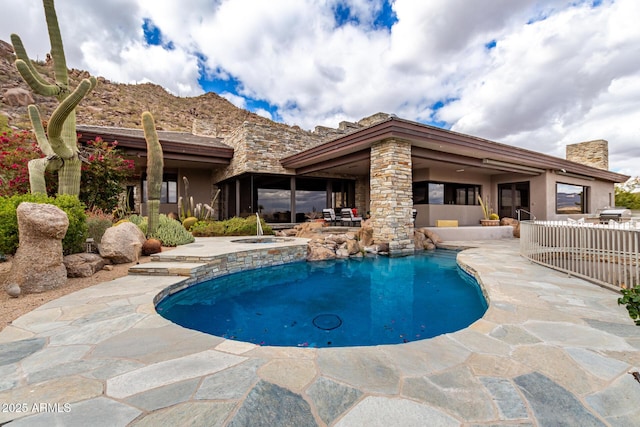 outdoor pool with a patio area, area for grilling, and an in ground hot tub