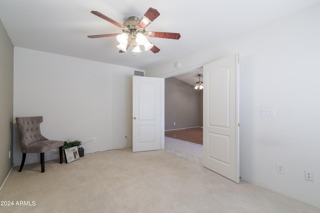 unfurnished room featuring ceiling fan and light colored carpet