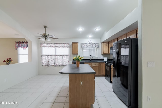 kitchen with a kitchen island, sink, black appliances, light tile patterned floors, and ceiling fan