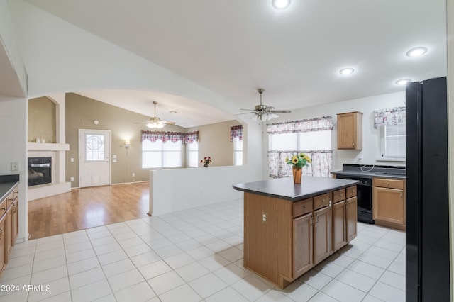 kitchen with a center island, a healthy amount of sunlight, black appliances, and light tile patterned floors