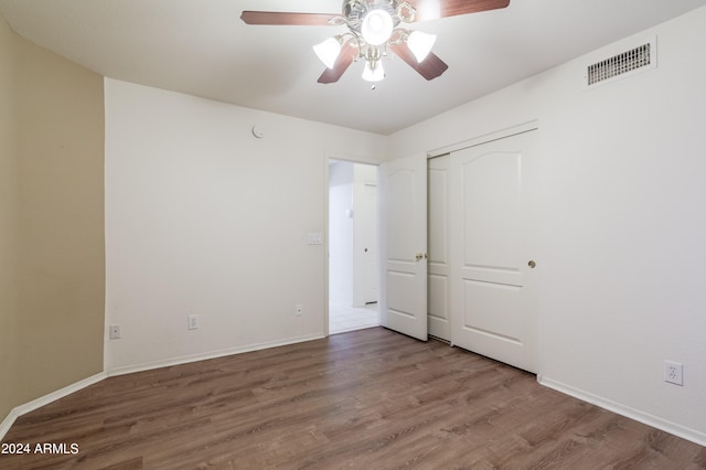 unfurnished bedroom with a closet, ceiling fan, and hardwood / wood-style flooring