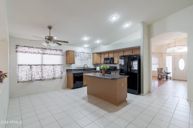 kitchen with black appliances, light tile patterned flooring, a kitchen island, ceiling fan, and lofted ceiling