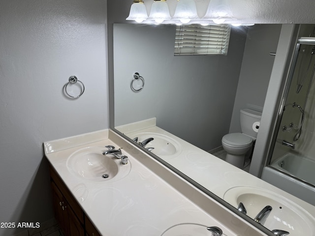 bathroom with double vanity, shower / bath combination with glass door, and a sink