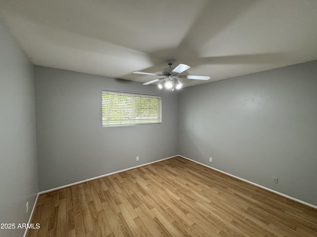 empty room featuring light wood-style flooring, a ceiling fan, and baseboards