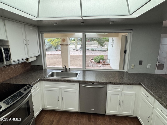 kitchen featuring dark wood finished floors, plenty of natural light, appliances with stainless steel finishes, and a sink