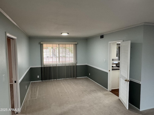 unfurnished room with visible vents, baseboards, carpet, and ornamental molding