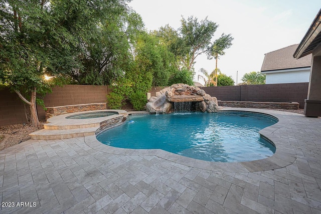 view of pool featuring an in ground hot tub, pool water feature, and a patio area