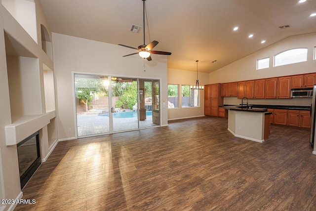 kitchen featuring pendant lighting, dark wood-type flooring, high vaulted ceiling, sink, and ceiling fan