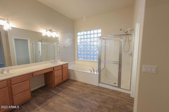 bathroom with hardwood / wood-style floors, vanity, and shower with separate bathtub