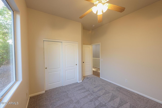 unfurnished bedroom featuring carpet flooring, ceiling fan, and a closet