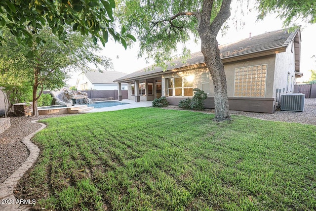 back of property featuring a yard, a fenced in pool, a patio, and central AC unit