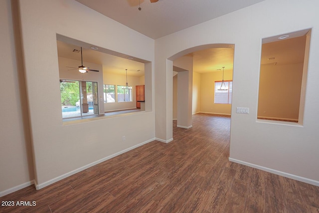 spare room featuring hardwood / wood-style flooring and ceiling fan with notable chandelier