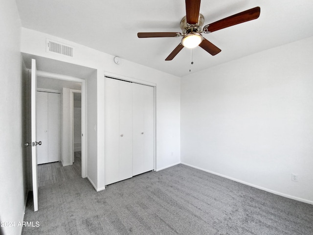 unfurnished bedroom featuring ceiling fan, a closet, and light carpet