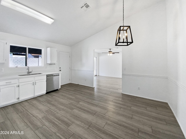 kitchen with pendant lighting, stainless steel dishwasher, vaulted ceiling, and light hardwood / wood-style floors