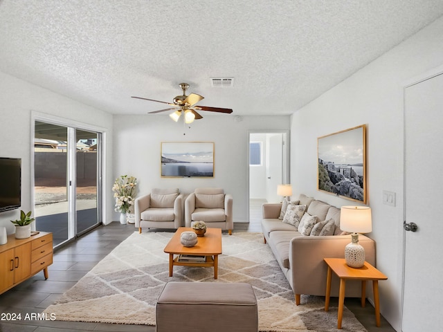 living room with ceiling fan, hardwood / wood-style floors, and a textured ceiling