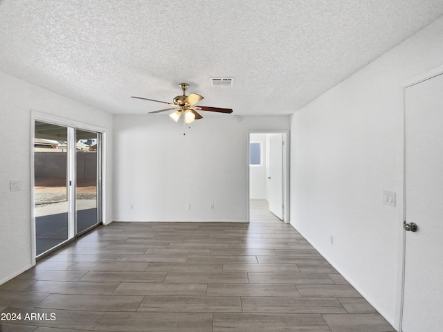 spare room featuring ceiling fan, dark hardwood / wood-style floors, and a textured ceiling